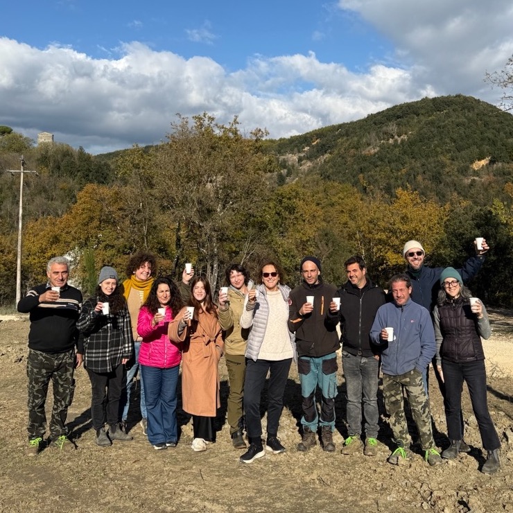 Spannocchia staff stand together, facing the camera, with cups raised in "cheers."